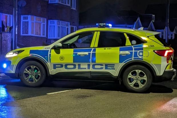 Man arrested after car flips in late-night crash with parked vehicle