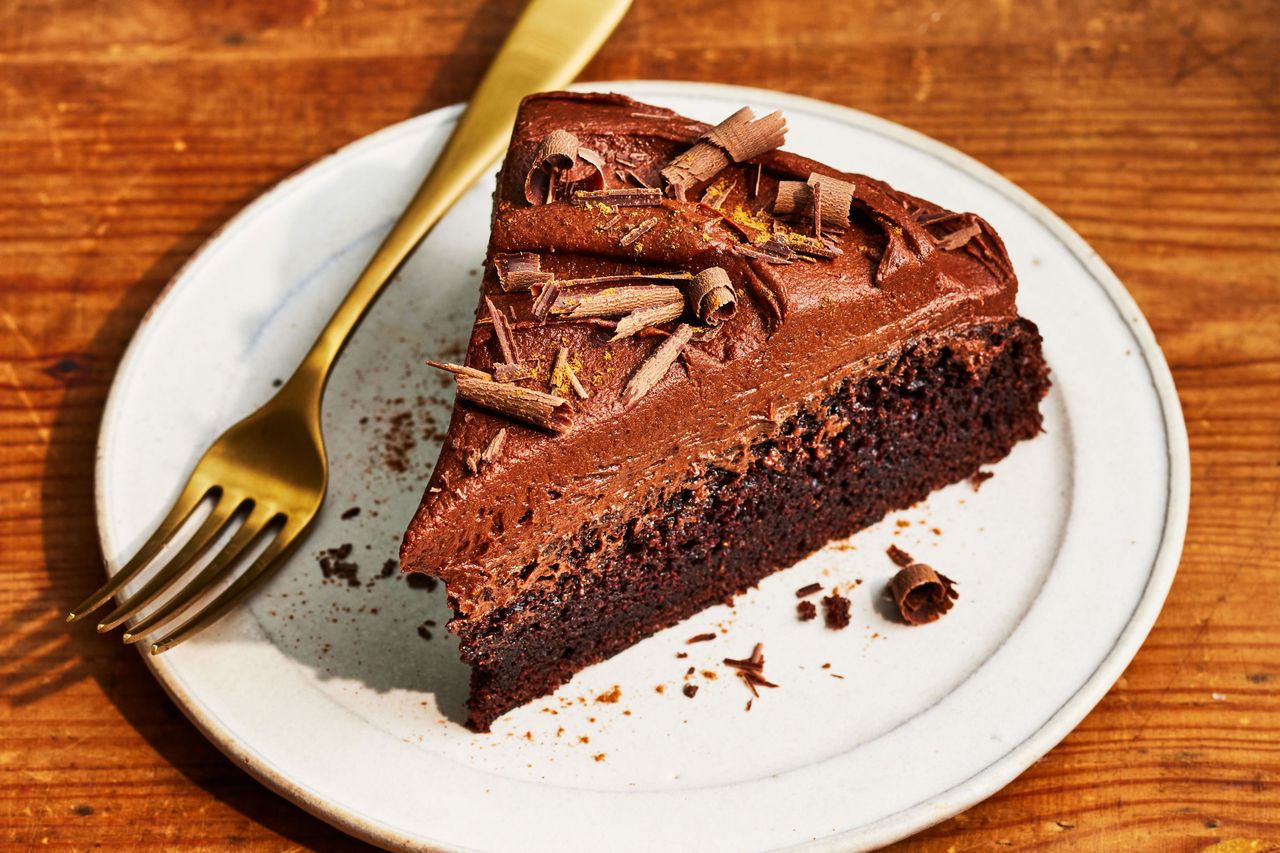 Southern Living Chocolate Cake with Spiced Chocolate Buttercream sliced on a plate to serve topped with chocolate curls
