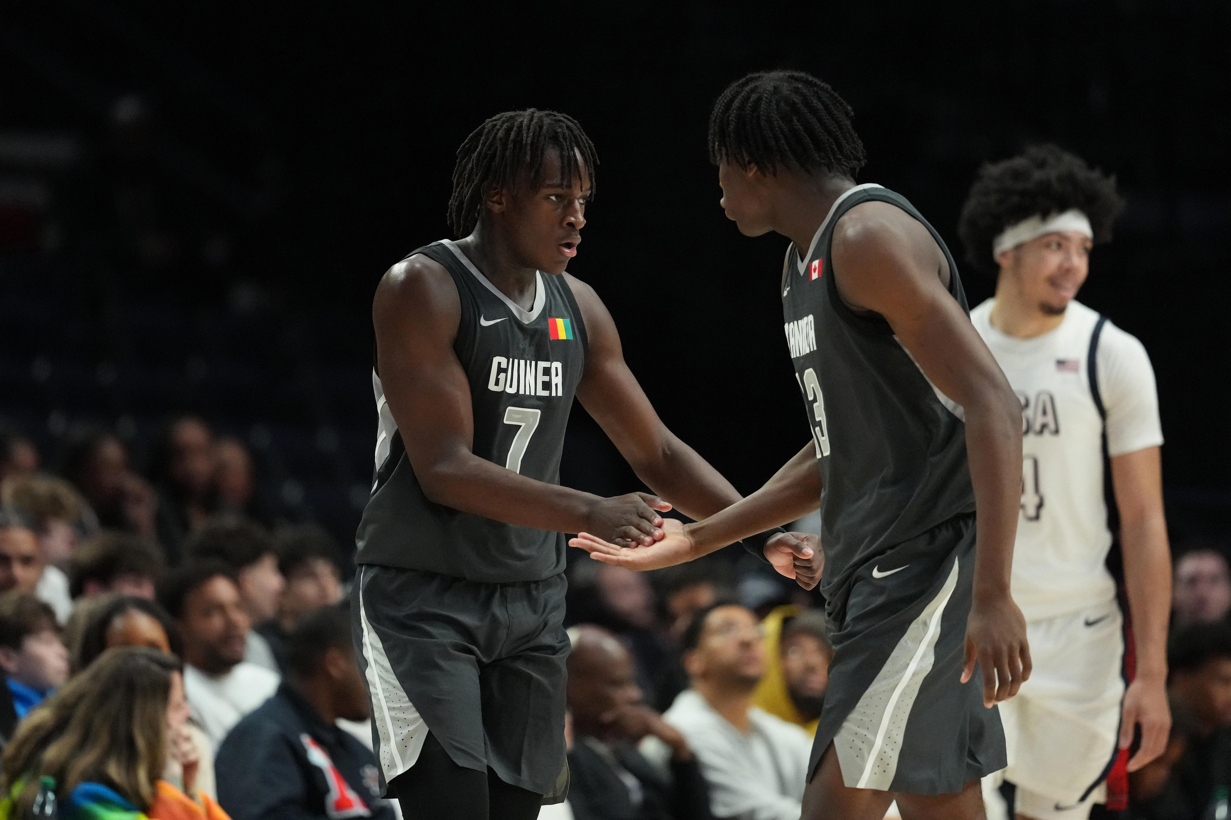 PORTLAND, OREGON - APRIL 11: Abdou Toure #7 and Paul Osaruyi #13 of Team World high five during the second half against Team USA at Moda Center on April 11, 2026 in Portland, Oregon. (Photo by Soobum Im/Getty Images)