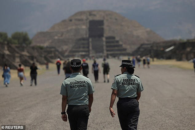 Tourists smile in front of Mexican pyramid with no idea that human ...