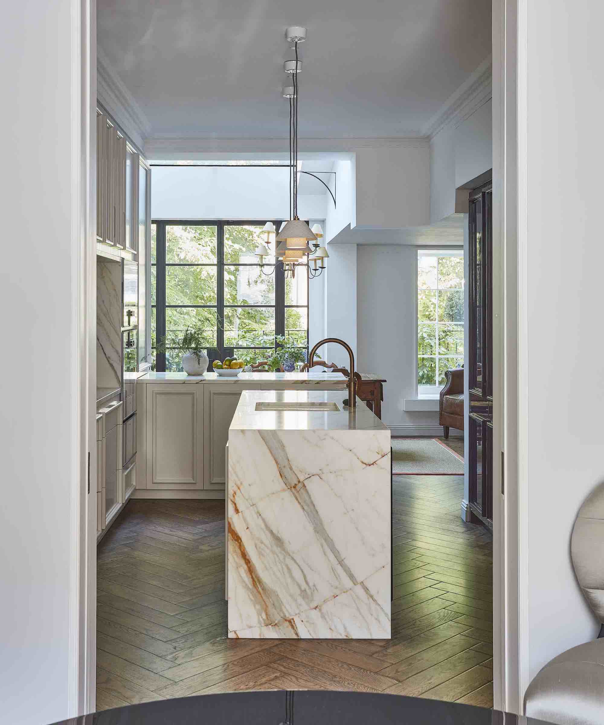 pale kitchen with island featuring marble waterfall edge