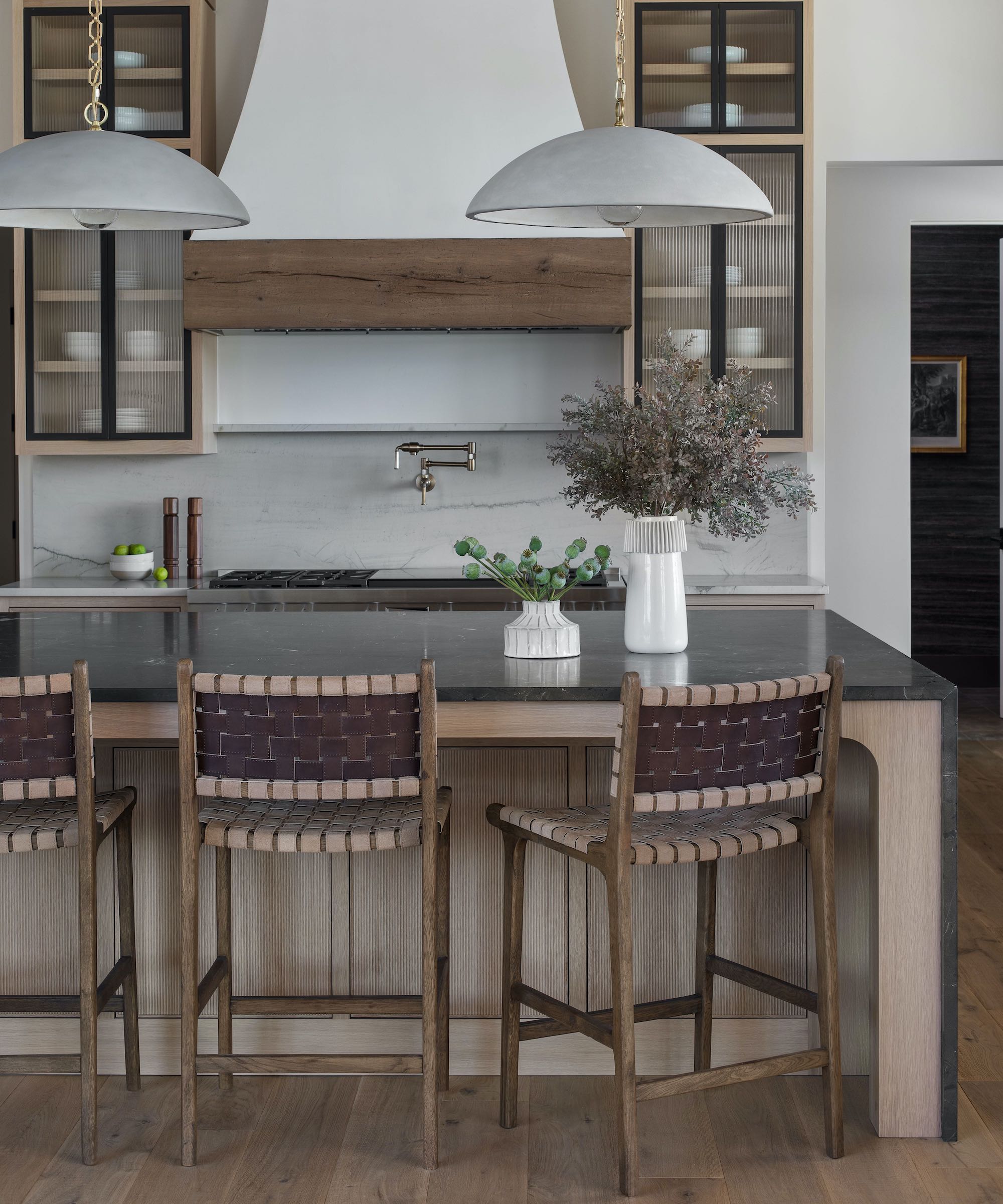 kitchen with wood island and high-back stools and marble tops