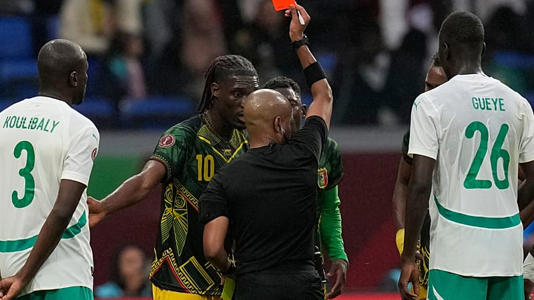 L'arbitre Abongile Tom brandit un carton rouge à l'encontre du Malien Yves Bissouma lors du 1/4 de la CAN 2025 opposant le Sénégal au Mali, au Maroc, le 9 janvier 2026