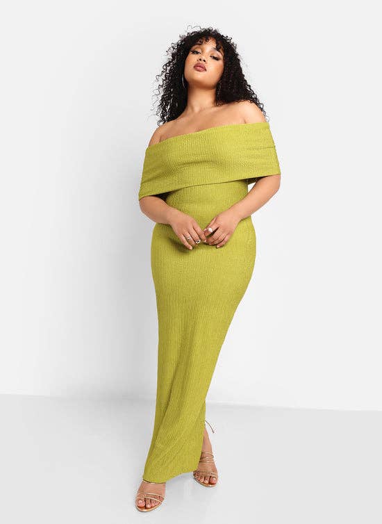 Person in an off-shoulder, knit maxi dress poses confidently