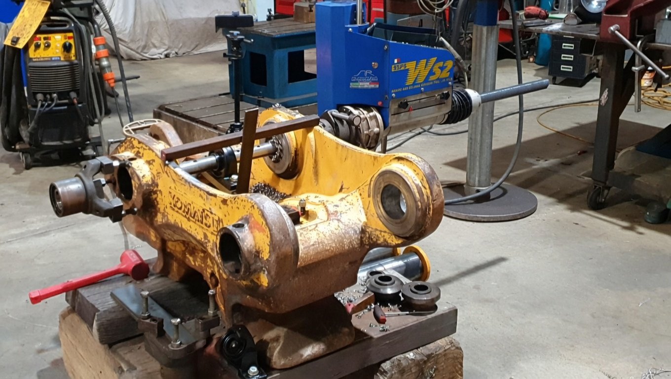 Line boring and welding a quick hitch excavator