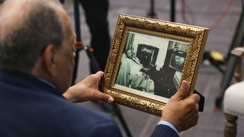 Ambassador Andrew Young examines a 1965 photo of Martin Luther King Jr. watching President Lyndon B. Johnson addressing Congress on TV. Young was in the room with King at the time. - Austin Steele/CNN