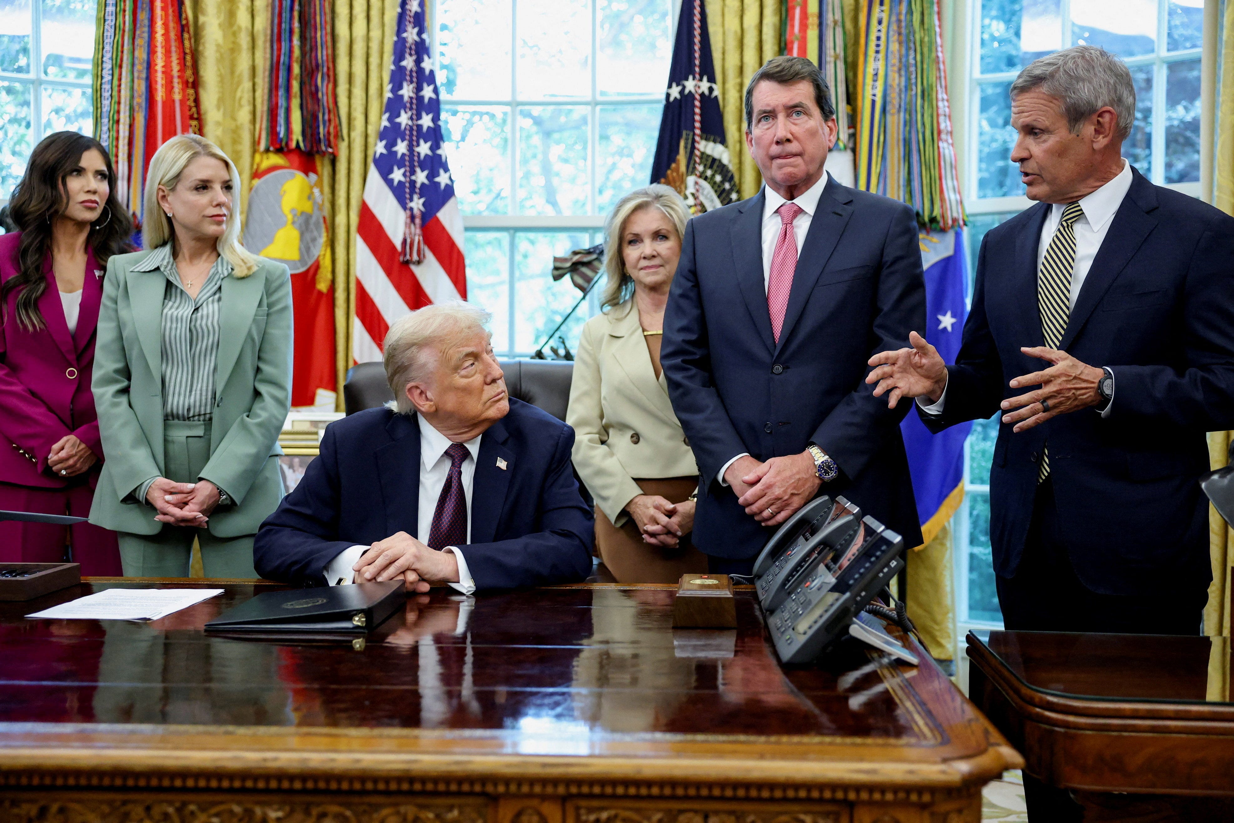 President Donald Trump listens while Tennessee Governor Bill Lee speaks during an event to sign a memorandum to send federal resources to Memphis, Tennessee.