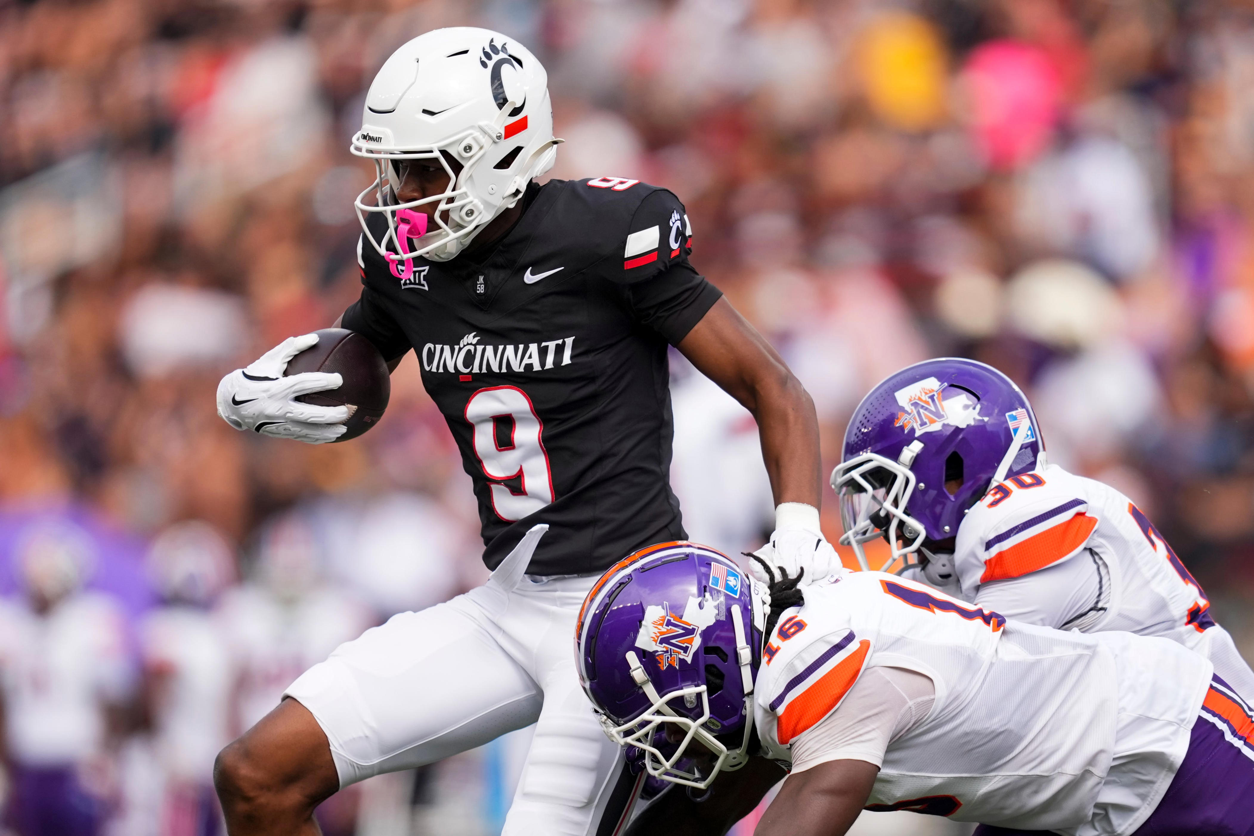 Sep 13, 2025; Cincinnati, Ohio, USA; Cincinnati Bearcats wide receiver Jeff Caldwell (9) makes a catch against Northwestern State Demons linebacker Kolbe Cage (16) and cornerback Troy Santa Marina Jr. (30) in the first half at Nippert Stadium. Mandatory Credit: Aaron Doster-Imagn Images