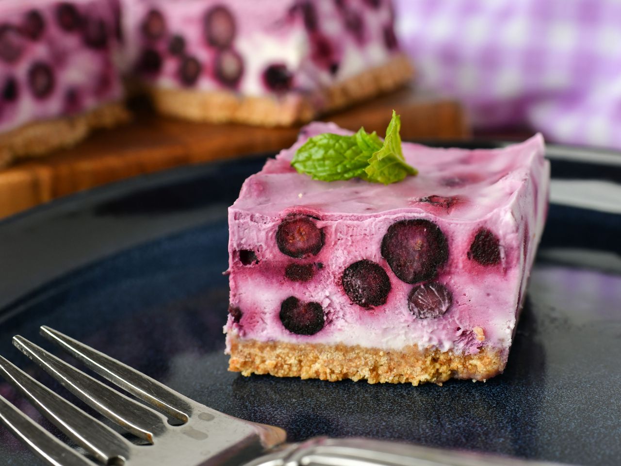 Piece of no bake blueberry squares garnished with mint leaf
