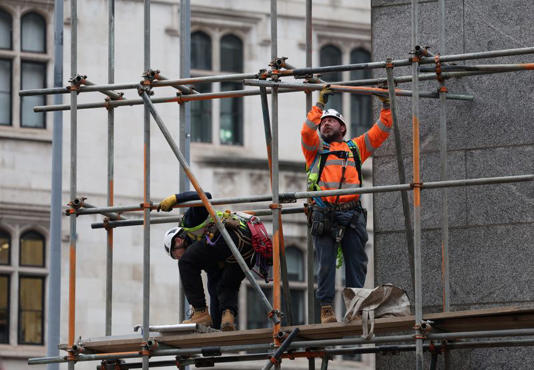 Construction workers work on a scaffolding at an office building, in London, Britain, January 16, 2025. REUTERS/Isabel Infantes