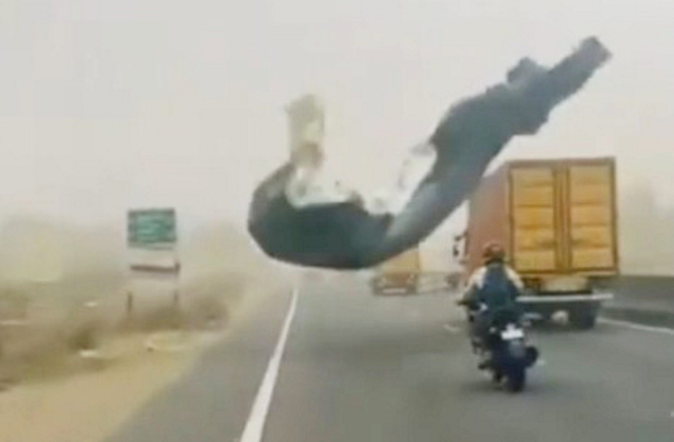 Moment rider crashes after banner is blown onto busy road