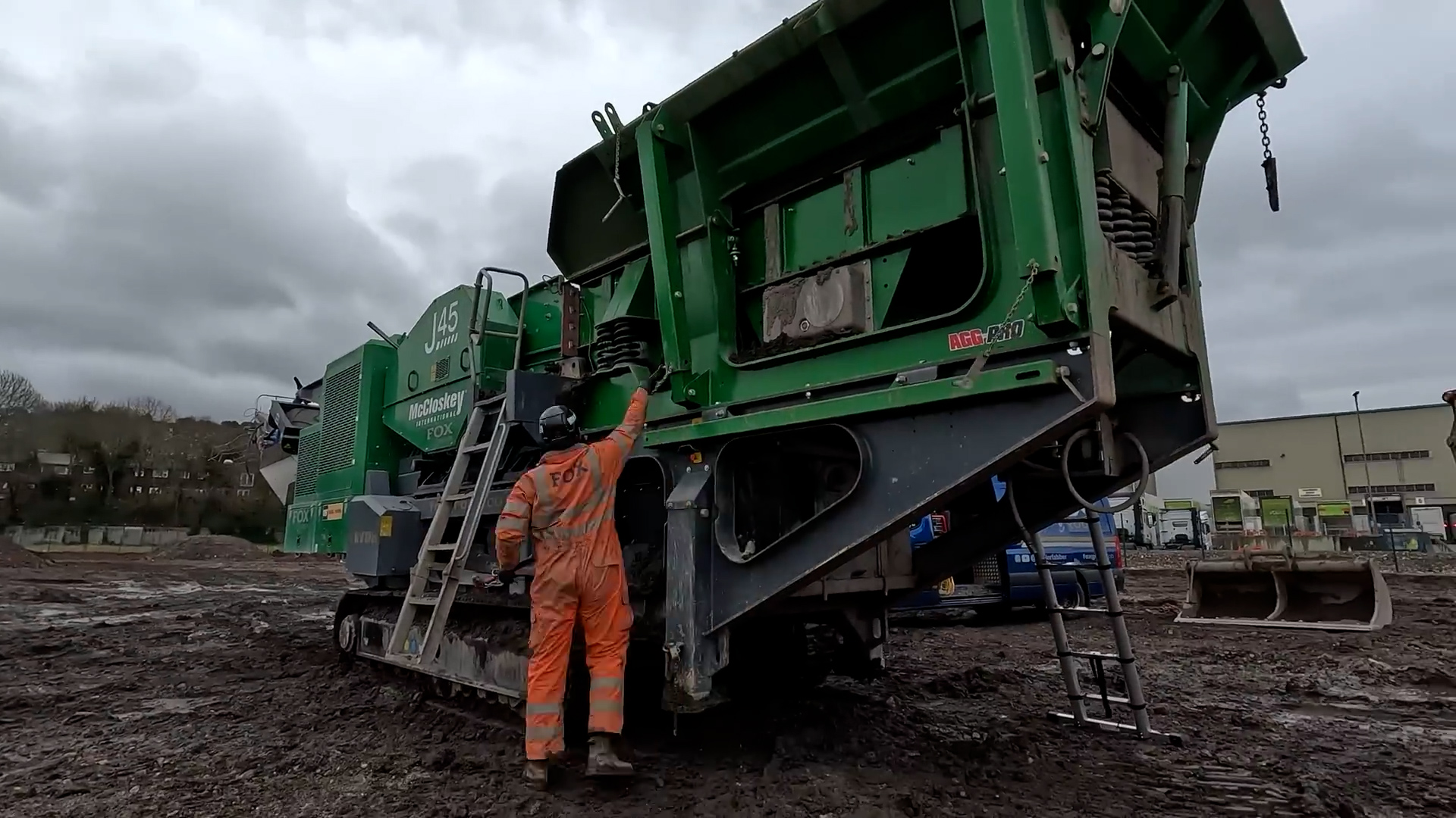 Inspecting a mobile screening plant at a muddy construction site