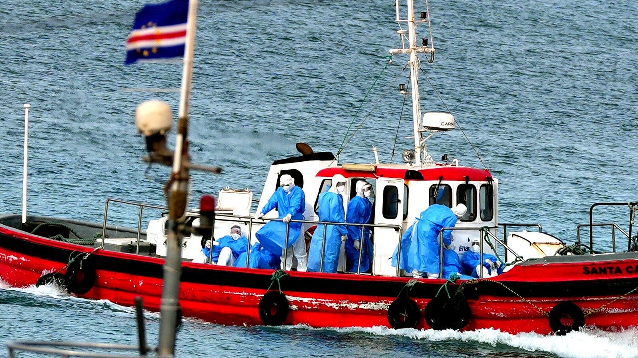 Health workers in protective gear evacuate patients from the MV Hondius cruise ship at a port in Praia, Cape Verde, on May 6, 2026.