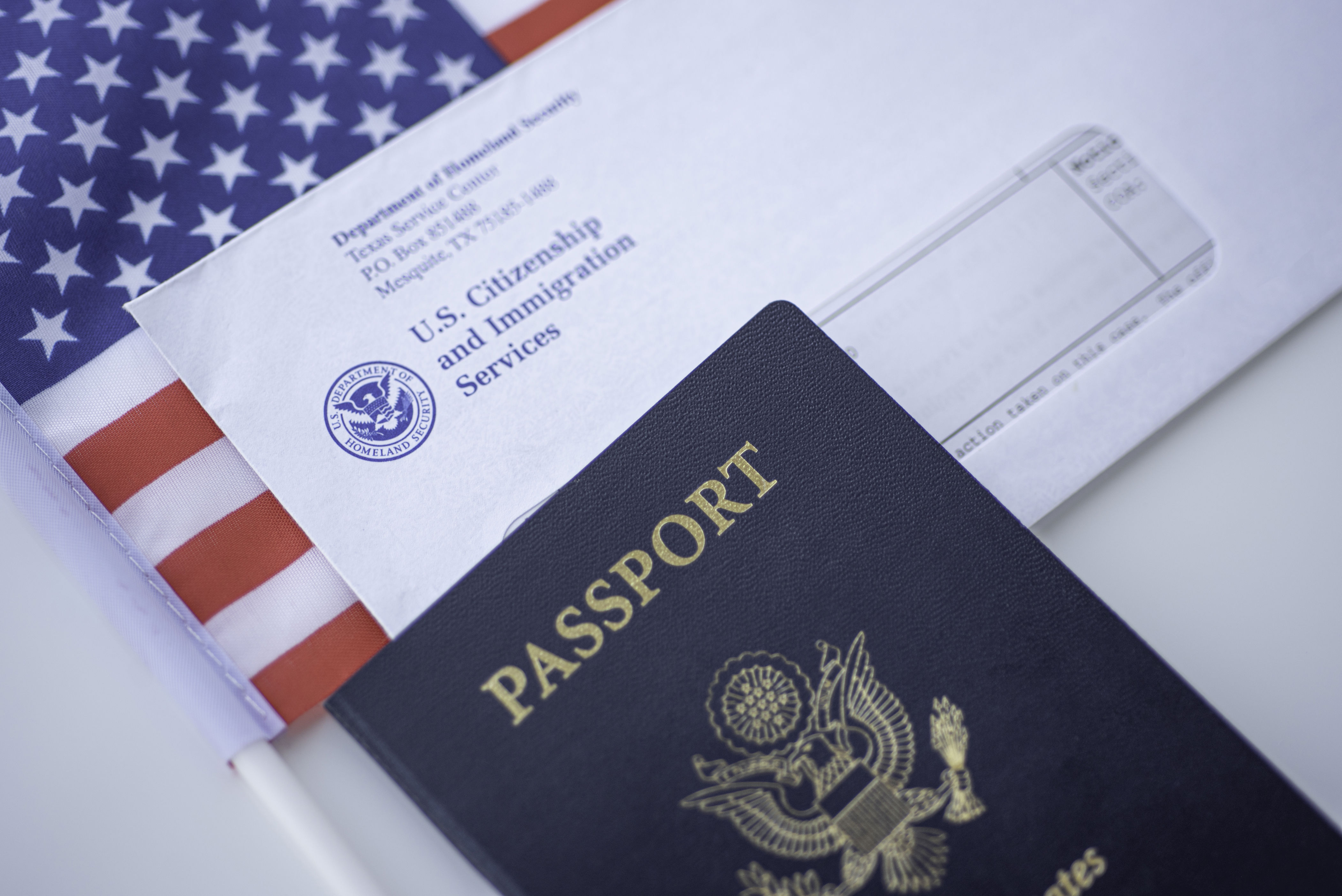 Passport of USA next to the Blurred Letter from USCIS and American flag.