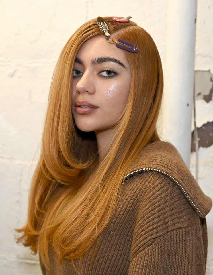 Person with long hair styled wearing clips and a sweater