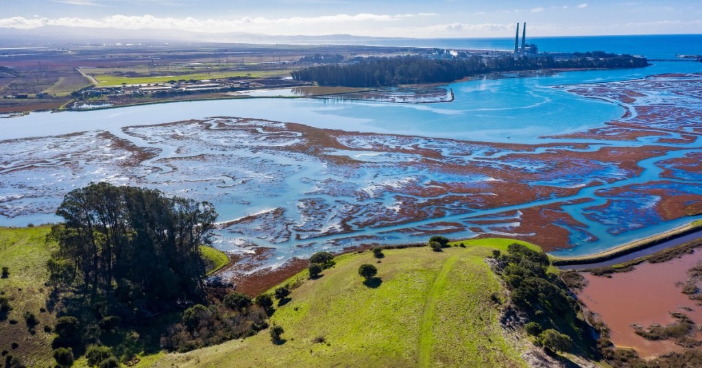 The town of Moss Landing, California, and the Elkhorn Slough area are seen from above on a sunny day.