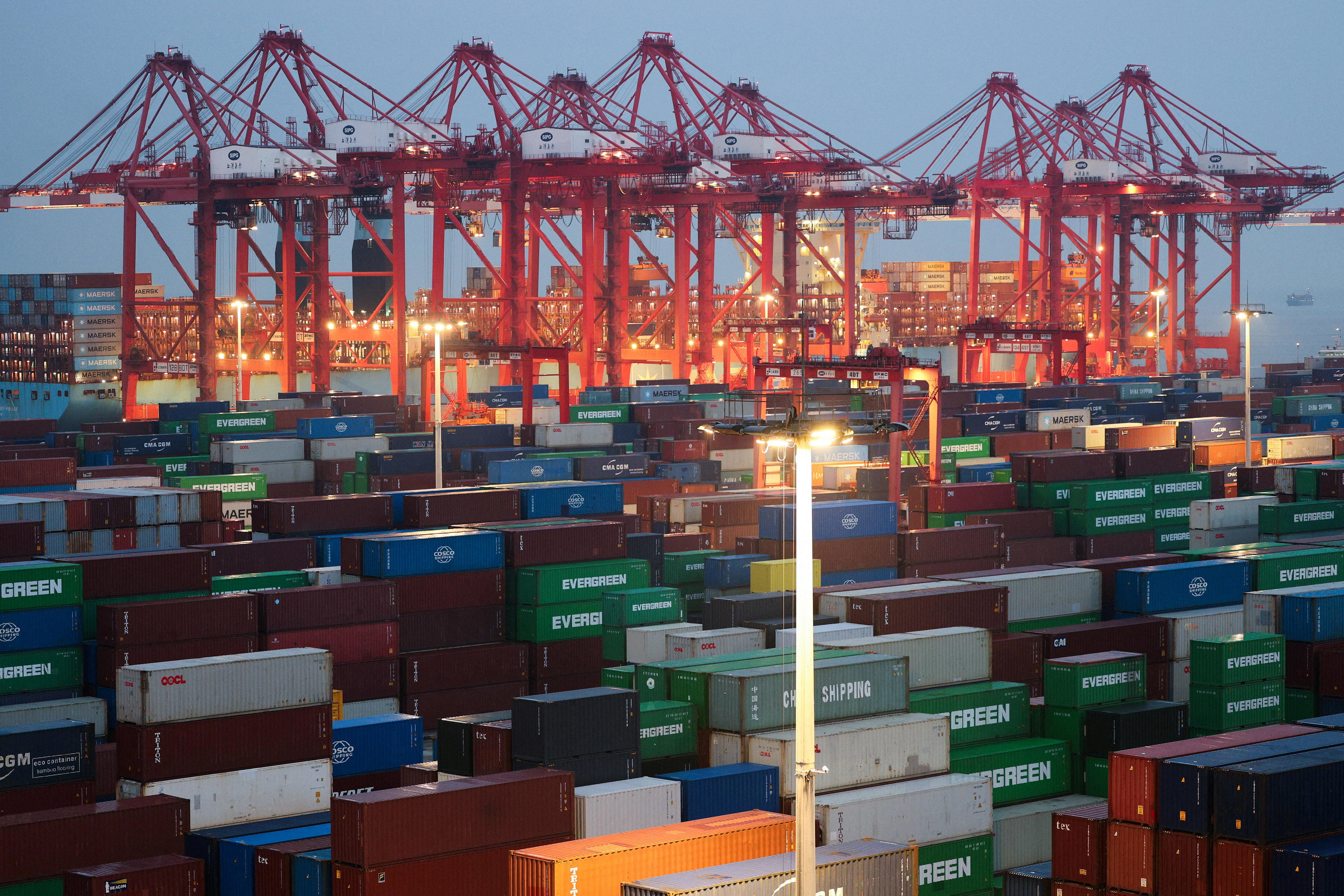 Gantry cranes stand near stacked shipping containers at Yangshan Port outside Shanghai, China, May 7, 2026.