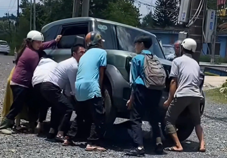 Người lớn, trẻ em hợp sức nâng ô tô điện cứu học sinh kẹt dưới gầm