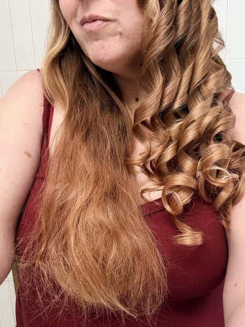 reviewer with half straight, half curled hair, wearing a sleeveless top