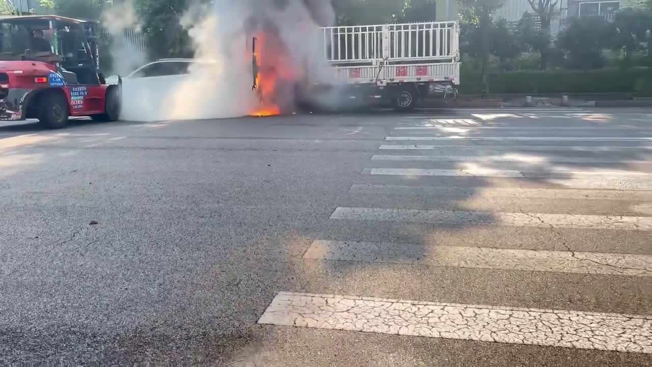 Parked car ignited by burning truck before forklift carries vehicle ...