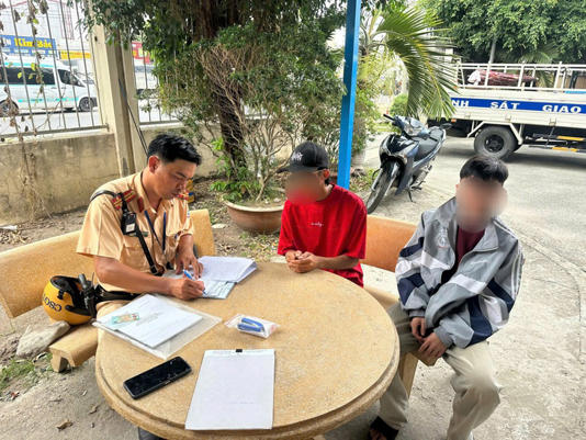 Nam thanh niên (áo đỏ) chạy xe lạng lách, đánh võng làm việc với cảnh sát giao thông - Ảnh: PC08