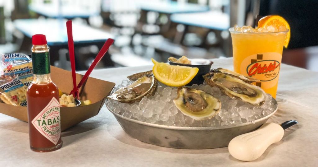 A table lined with Tabasco, oysters, and an orange crush at Chick's Beach restaurant in Chic's Beach - Hidden Waterfront Town VA