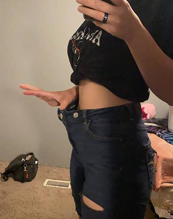 Reviewer showing loose waist of denim pants
