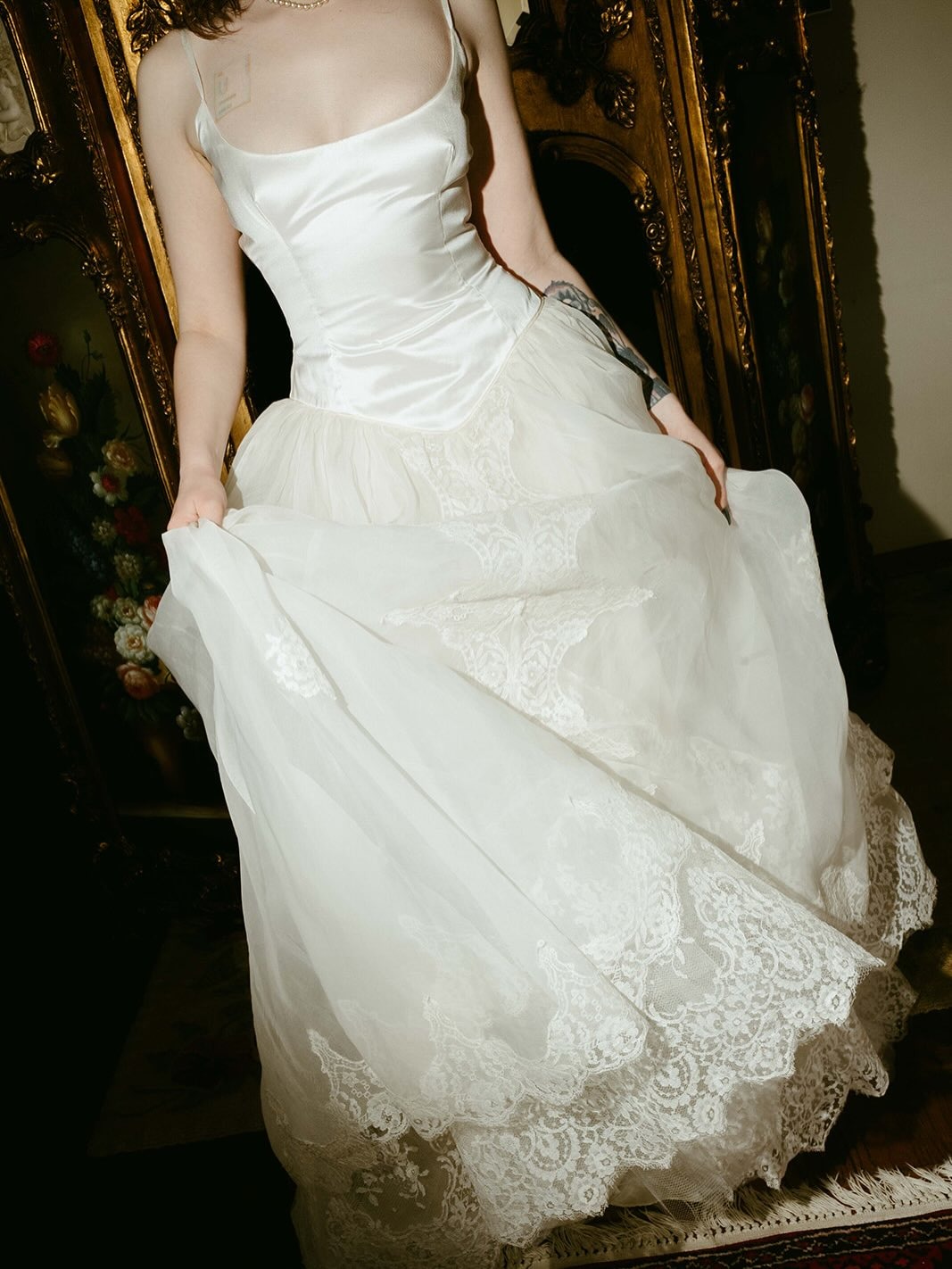 A woman wears a vintage wedding dress.
