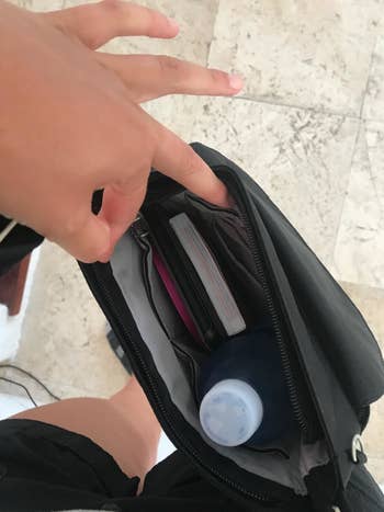 Reviewers' photo of the open bag in the color Black viewed from above, showing the contents including a water bottle and a notebook