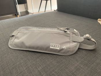 Reviewer's photo of a gray Peak Gear money belt with RFID protection on a couch