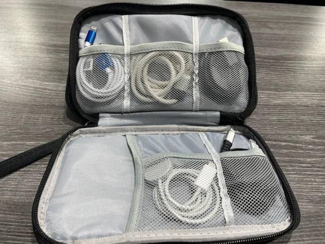 Reviewer's photo of the cable organizer in the color Black, open and displaying lots of cables