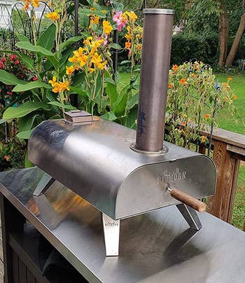reviewer photo of the pizza oven on top of an outdoor table