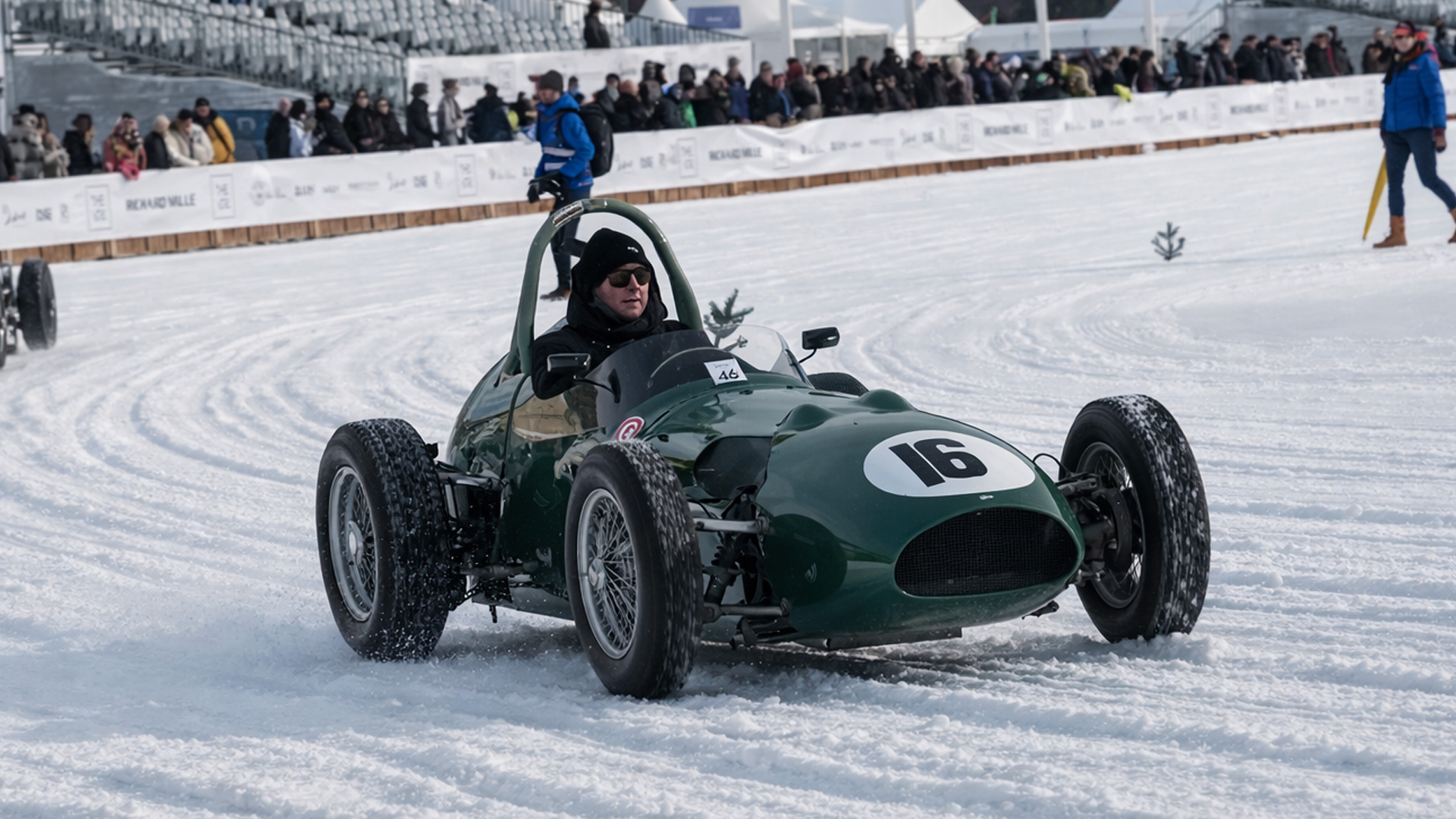 Classic Aston Martin race car is racing on an ice track