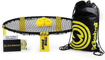 Spikeball game set with net, three balls, instructional guide, and black bag with yellow logo