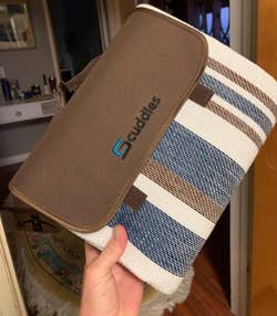 reviewer holding the blanket folded up into its pouch