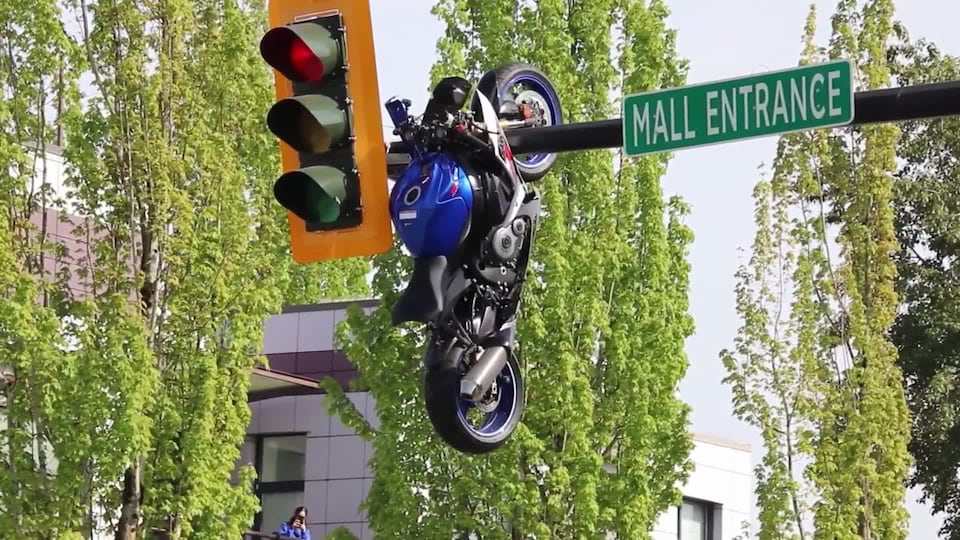 Watch: Motorcycle left hanging off traffic light after crash