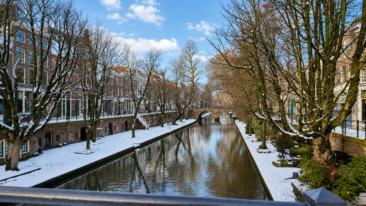 Snowy Utrecht canal walk with quiet bridges and winter reflections