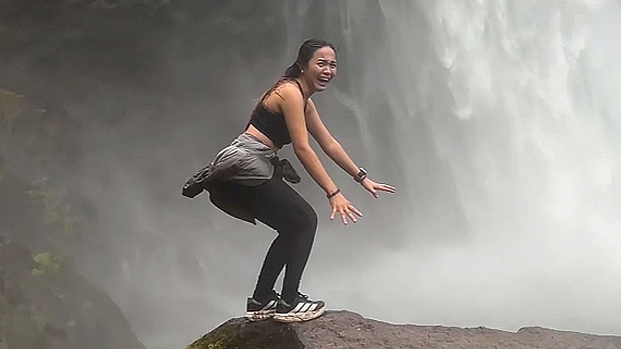 Woman hilariously struggles to pose for photo near massive waterfall in ...