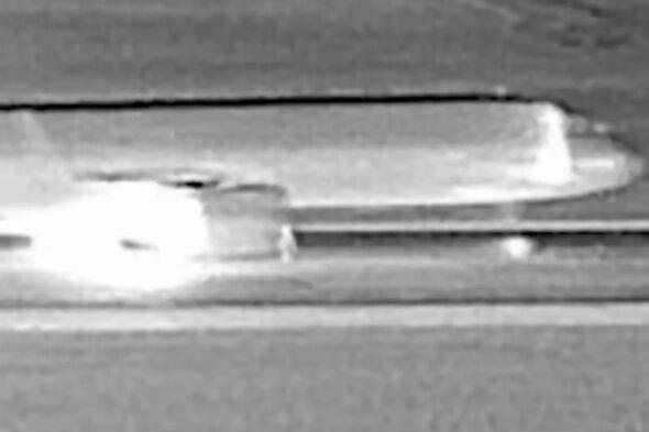 CCTV still of person in front of plane jet engine moments before take off