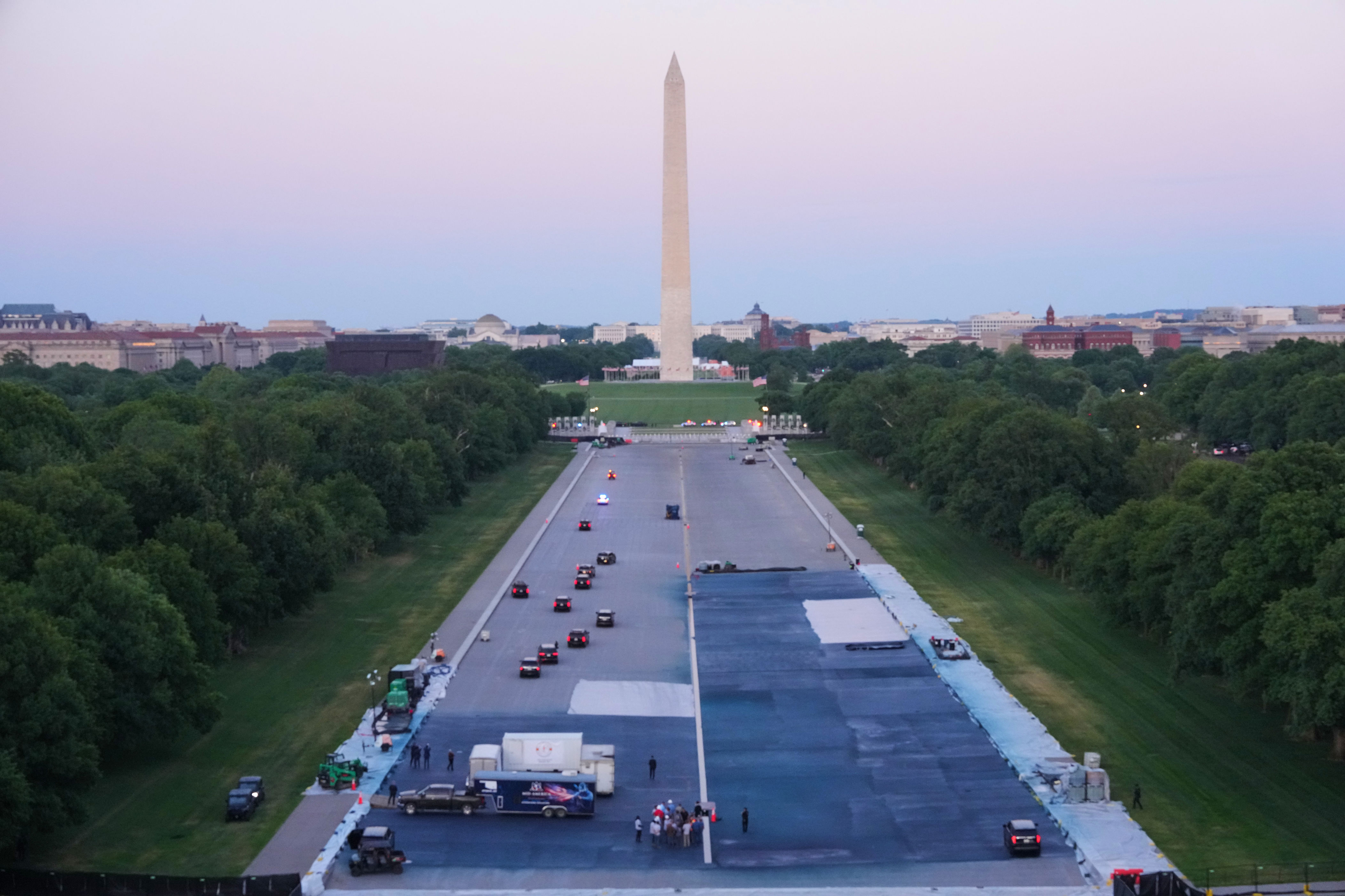 President Donald Trump's motorcade drives through the reflecting pool on May 7, 2026, as he surveys work he ordered to resurface the historic landmark's basin in a dark blue color.