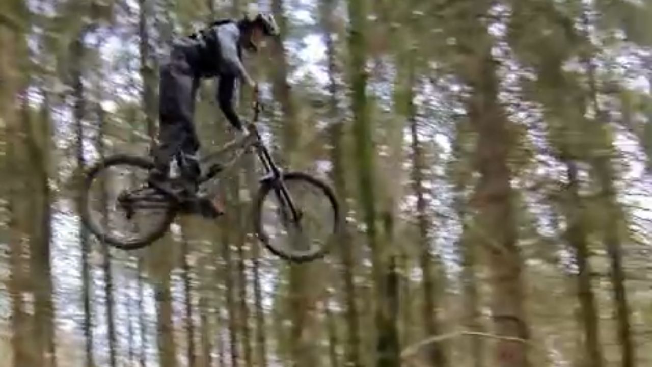 Biker slides across trail after losing control during jump moment