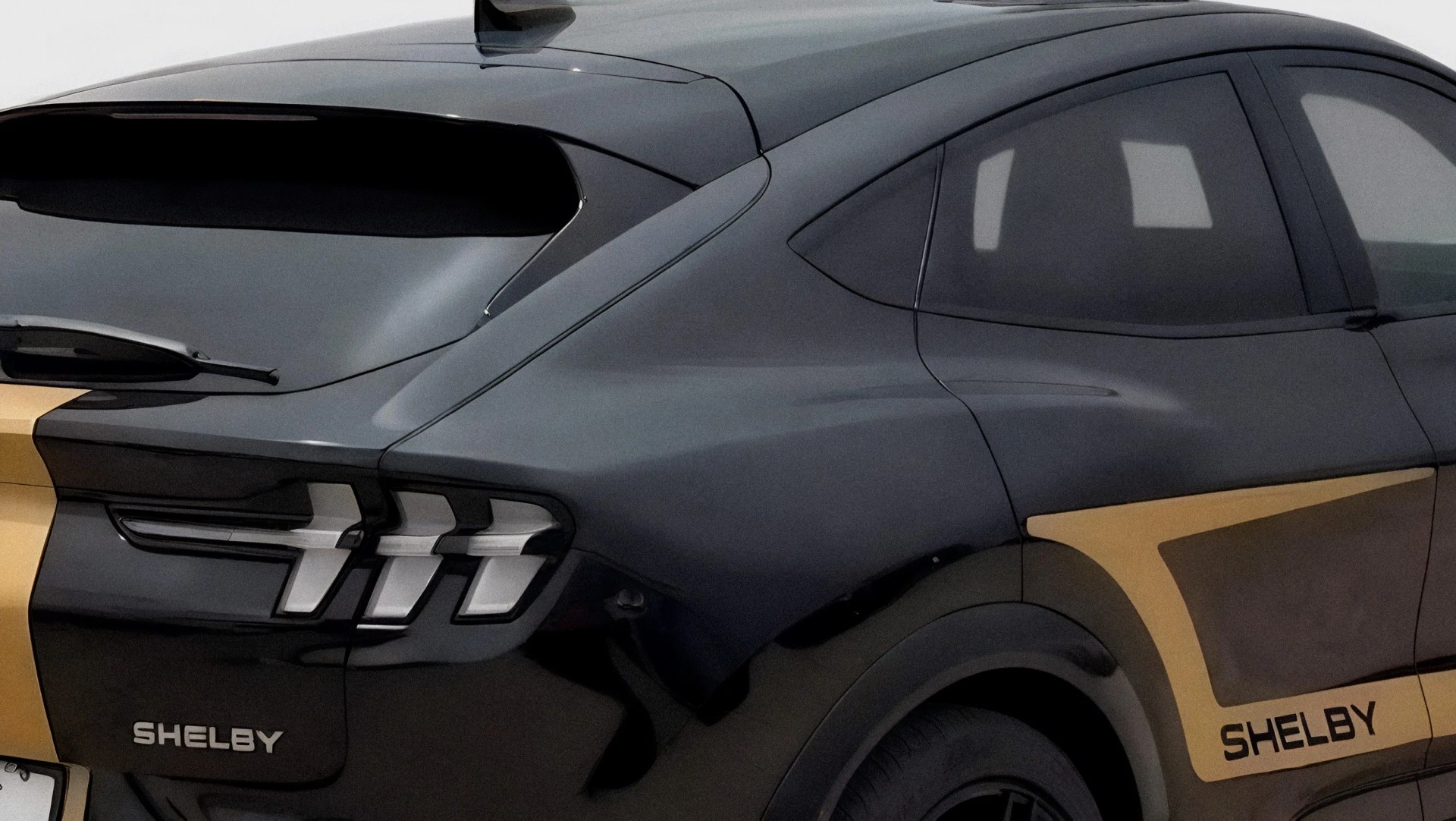 Rear side view of a black Shelby car with gold accents and distinctive vertical taillights.