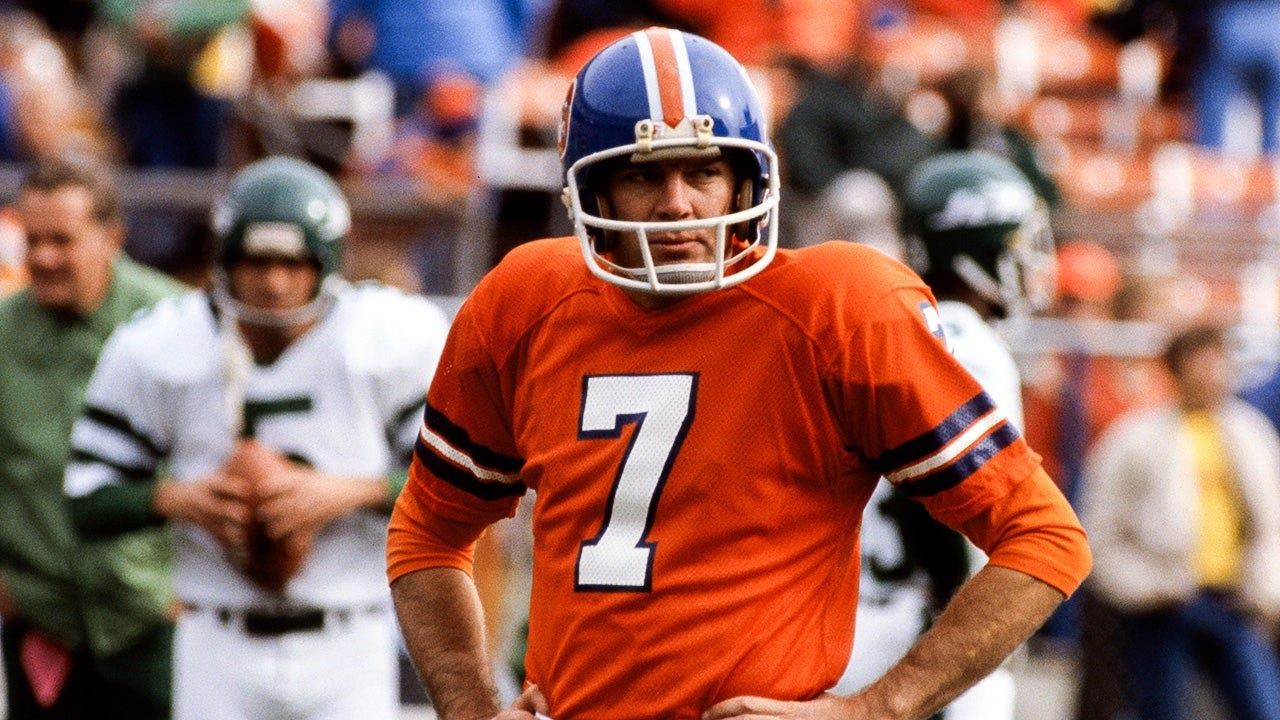 Denver Broncos quarterback Craig Morton stands on the sidelines with both hands on his hips.