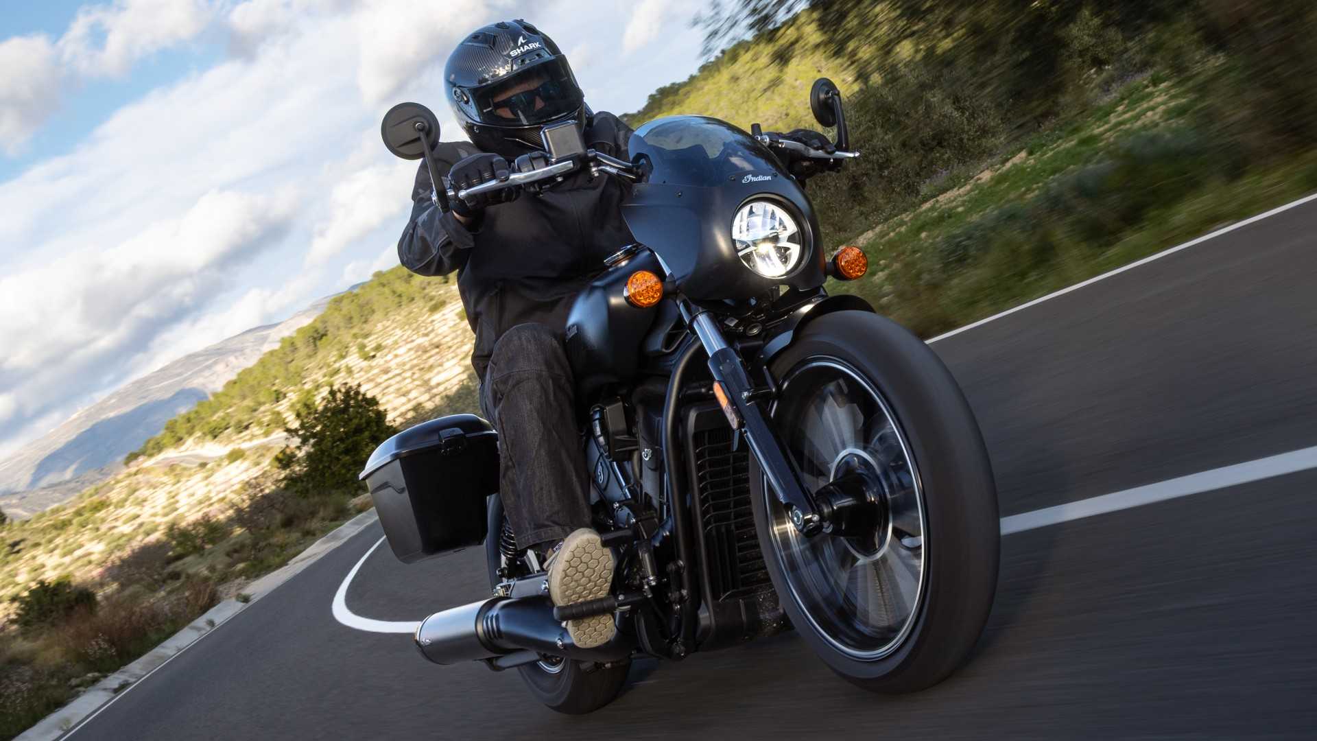 2026 Indian Sport Scout RT in black cornering along a winding road front third quarter view