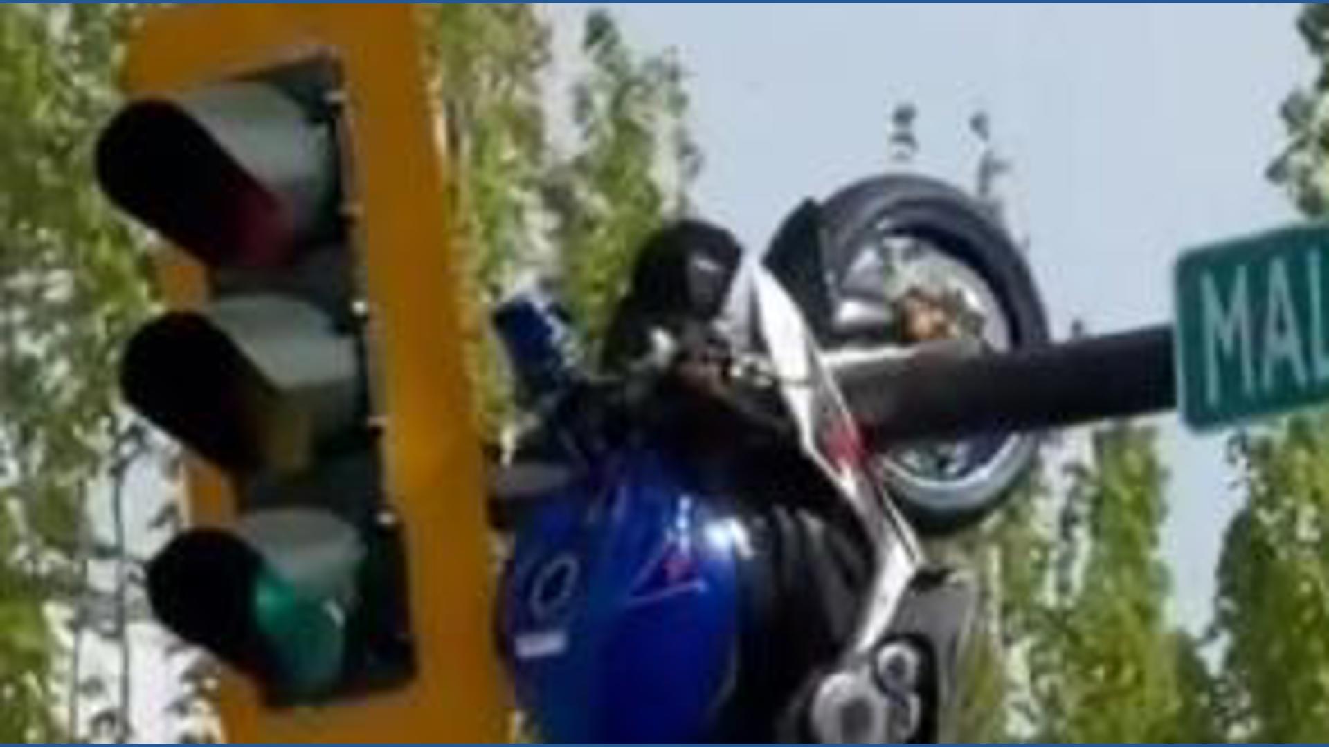 Motorcycle hangs from traffic light after crash