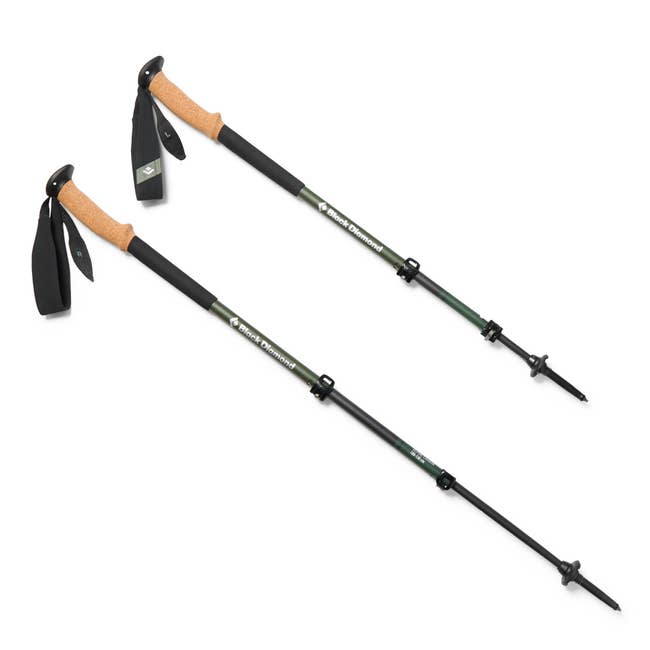 Two adjustable trekking poles with ergonomic cork handles and wrist straps, designed for outdoor hiking and climbing