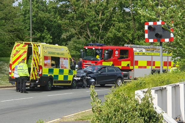 Three injured after crash between ambulance and car