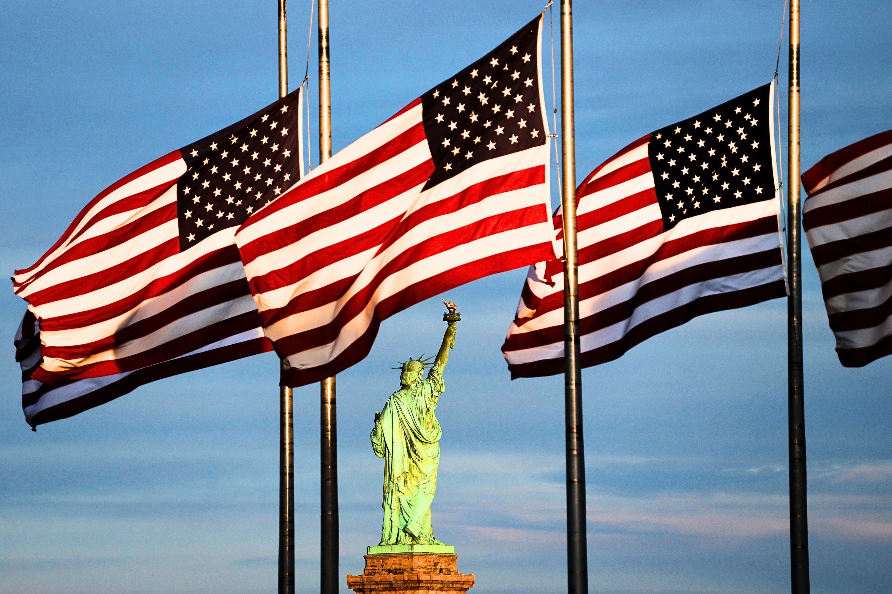 File image: The sun sets on the Statue of Liberty in New York City as flags in the Liberty State Park flag plaza fly at half staff honoring the victims of the school shooting earlier in the week in Minneapolis, Minnesota, on August 31, 2025, in Jersey City, New Jersey.
