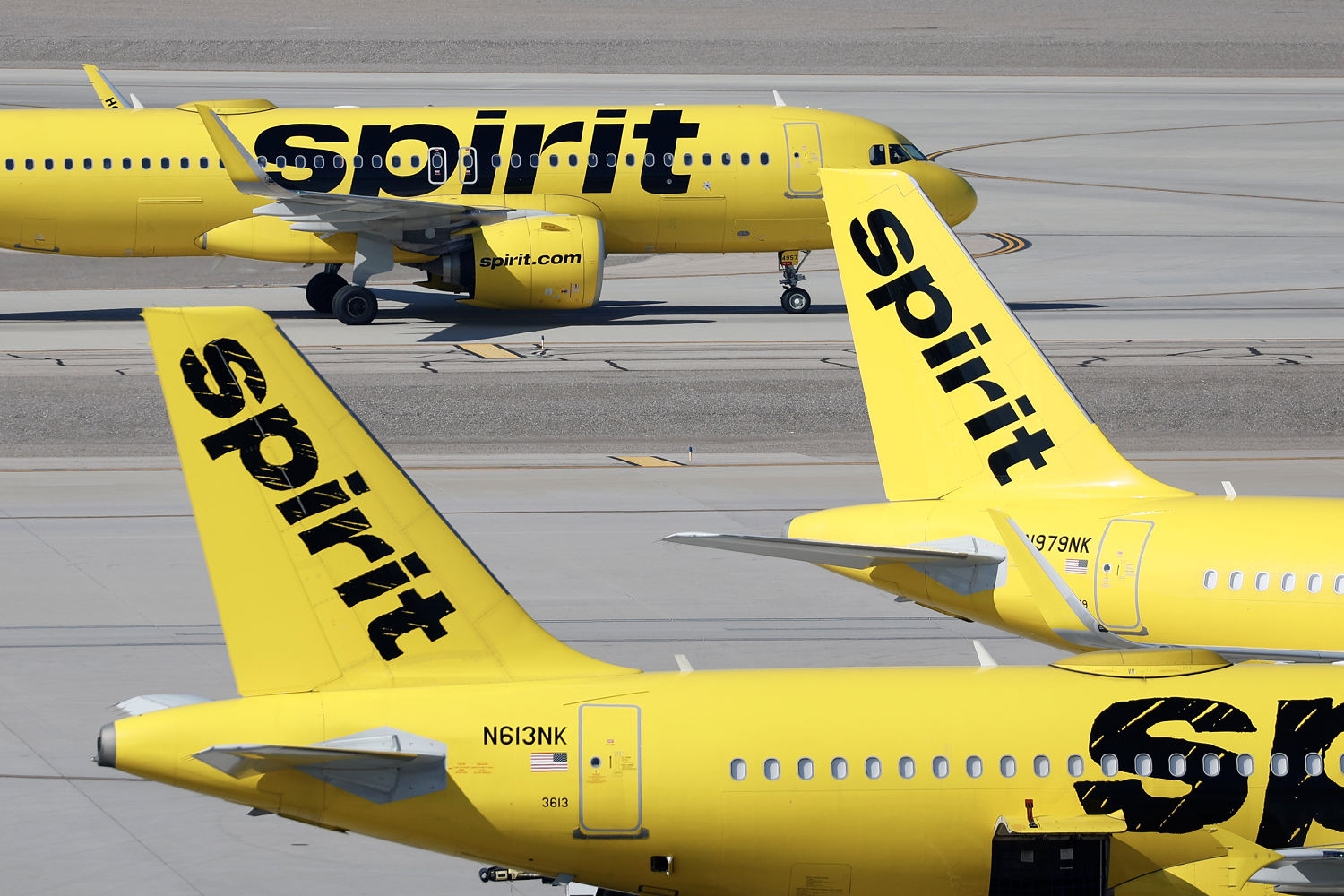 Three Spirit Airlines jets sitting on a tarmac.