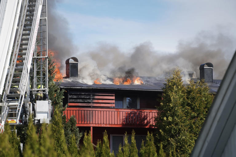 Flammene står gjennom taket på rekkehuset. Foto: Thomas Fure / NTB